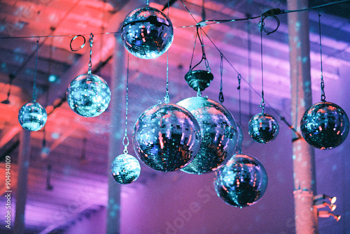 Hanging disco balls reflecting vibrant pink and blue lights.