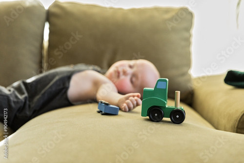 little boy sleeping napping on couch at daytime photo