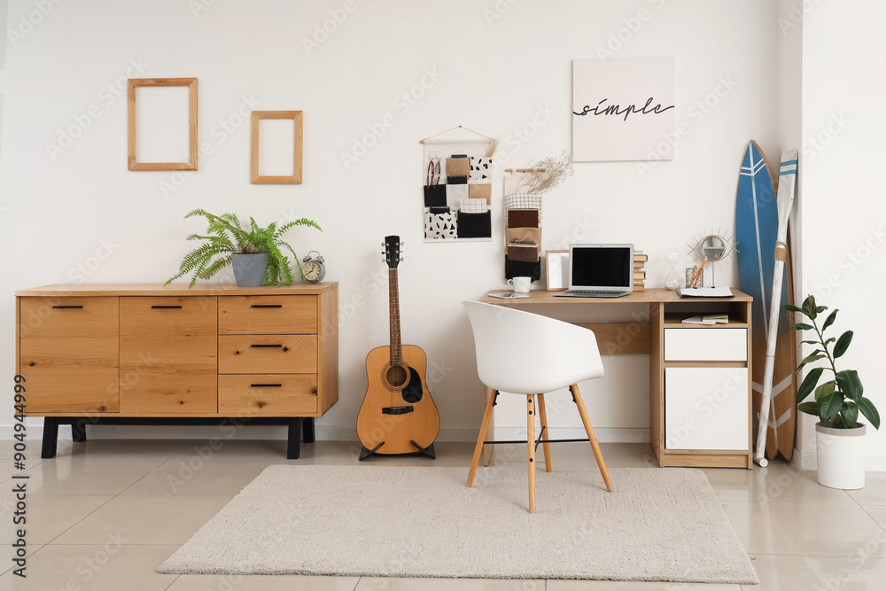 Interior of teenager's room with workplace, organizers and surfboard Interior of teenager's room with workplace, organizers and surfboard