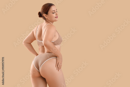 Canvastavla Beautiful plus size woman in underwear on beige background, back view