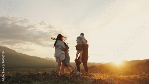  Parents circle and hug their children in the mountains at sunset. Happy family at sunset in the mountains. Family holiday in the mountains. Happy family concept. 