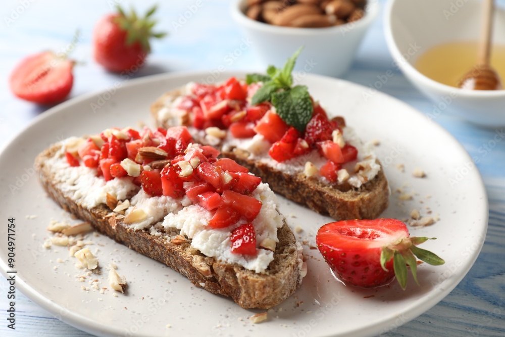 Bruschettas with ricotta cheese, chopped strawberries and mint on blue wooden table, closeup Bruschettas with ricotta cheese, chopped strawberries and mint on blue wooden table, closeup