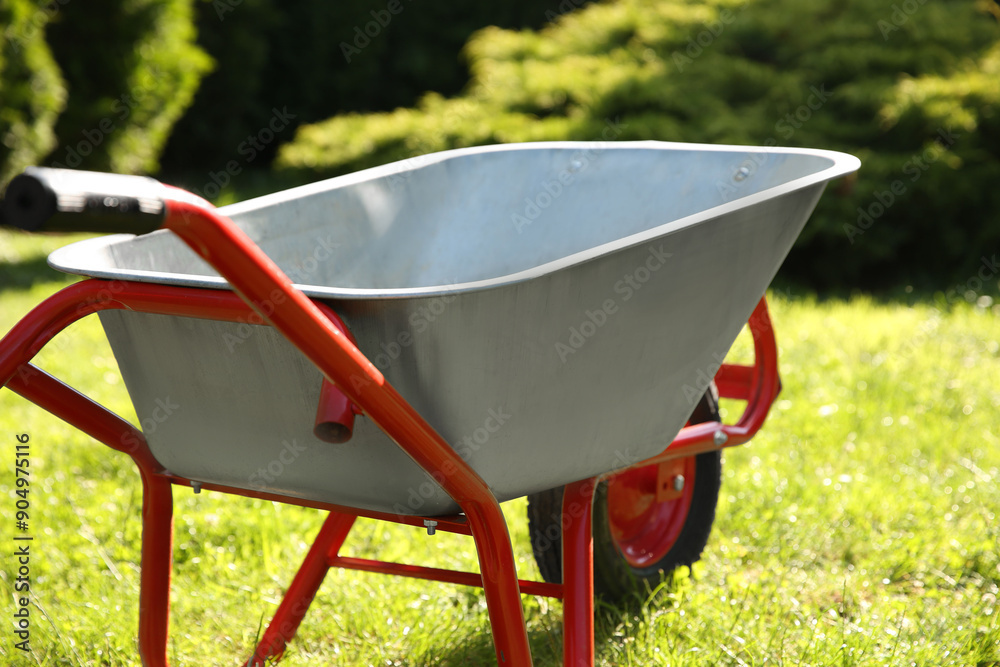 One wheelbarrow on green grass in garden One wheelbarrow on green grass in garden