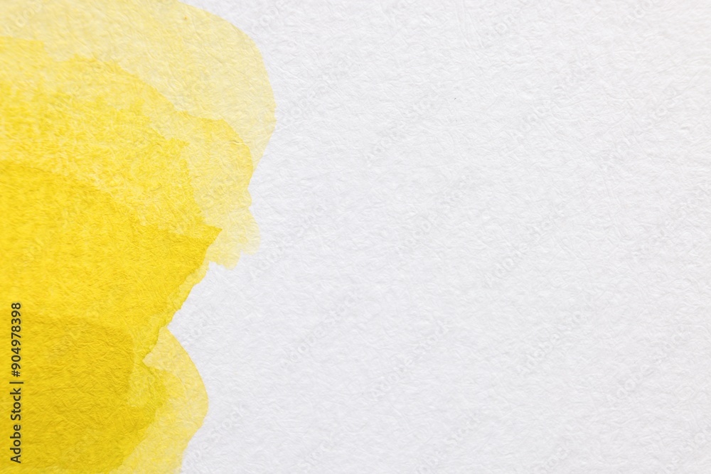 Yellow watercolor painting on white paper, top view. Space for text Yellow watercolor painting on white paper, top view. Space for text