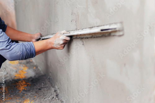 Concrete plasterers to create industrial workers background walls with plastering tools.