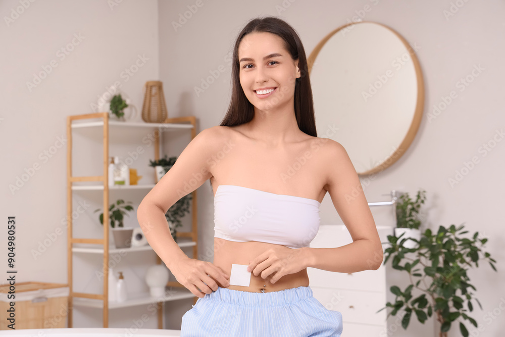 Young woman with applied contraceptive patch in bathroom Young woman with applied contraceptive patch in bathroom