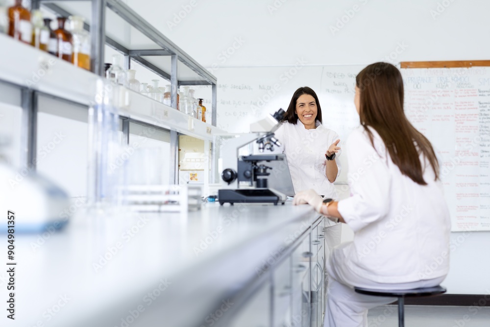Scientists discussing research in a modern laboratory. Scientists discussing research in a modern laboratory.
