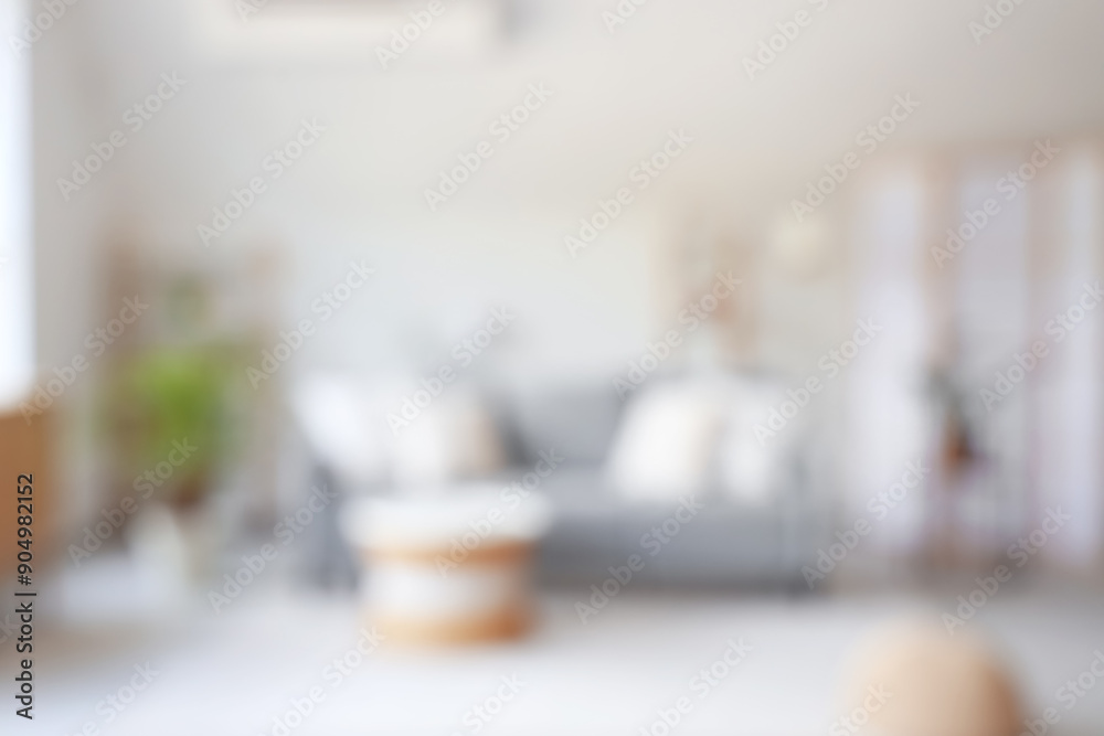 Blurred view of living room with grey sofa, table and shelf units Blurred view of living room with grey sofa, table and shelf units