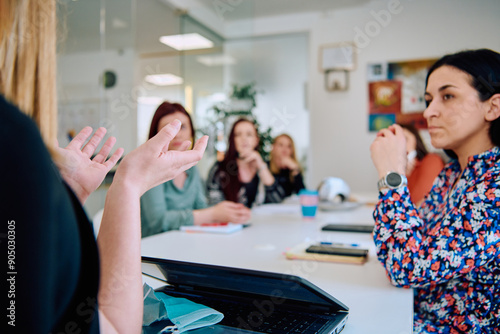 Diverse Business Team Discussing Projects in a Modern Glass Office. photo