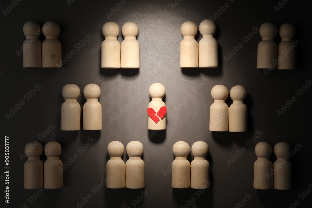 Obraz premium Loneliness concept. Single human figure with broken heart among couples on grey background, flat lay