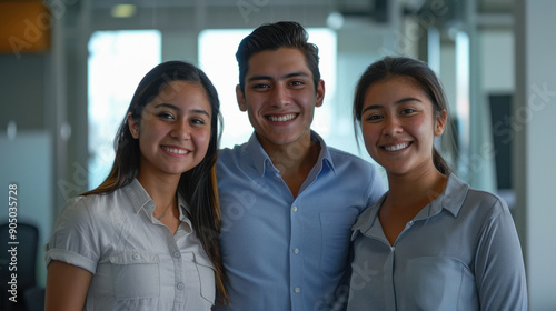 mexican coworkers standing together in the office smiling.