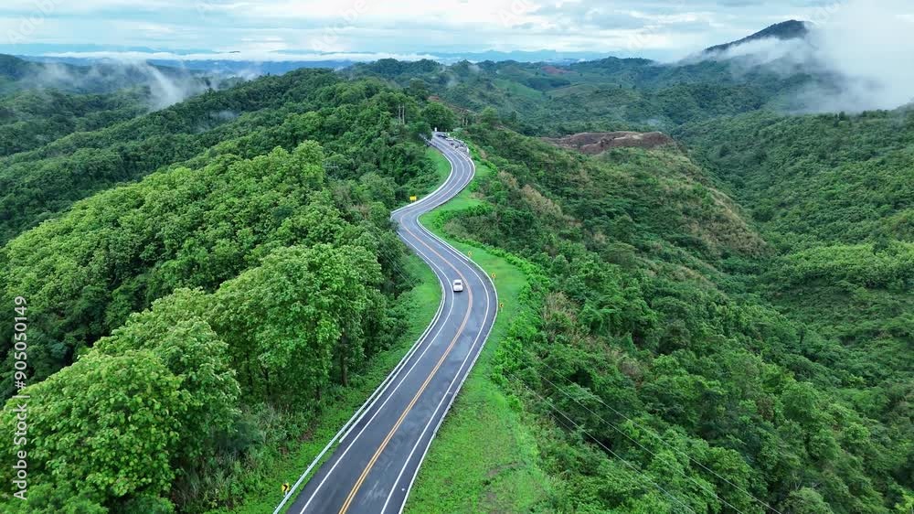 Aerial view highway Drone flying above winding road during sunlight, Winding asphalt road through tropical rainforest. countryside landscape. Landmark tourist attractions in Nan Province, Thailand. Aerial view highway Drone flying above winding road during sunlight, Winding asphalt road through tropical rainforest. countryside landscape. Landmark tourist attractions in Nan Province, Thailand.