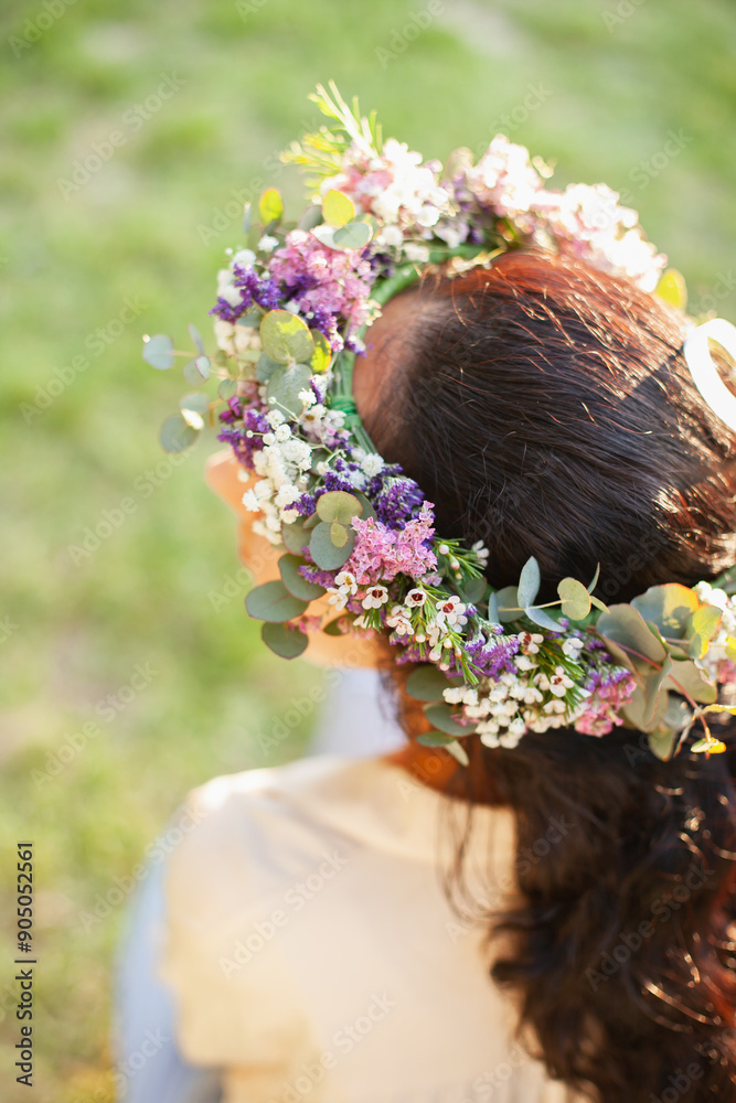 Naklejka premium woman brunette wearing flowers floral wreath - bridal florist accessories from above closeup with sunset light, boho style fashion