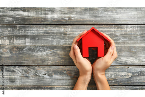 Overhead view on person hands holding red house model on wood background. Home for sale, for rent, mortgage concept. Saving money. Copy space photo