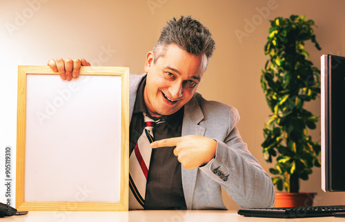 Sly salesman pointing at blank whiteboard in office