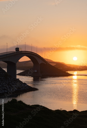 Midnight sun over a bridge in the Lofoten islands, Northern Norway with amazing orange light behind bridges