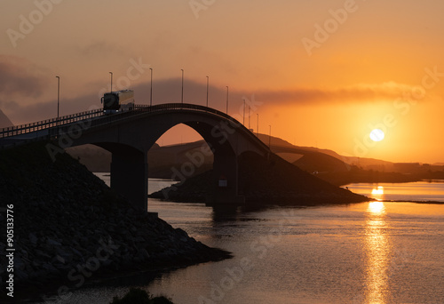 Midnight sun over a bridge in the Lofoten islands, Northern Norway with amazing orange light behind bridges