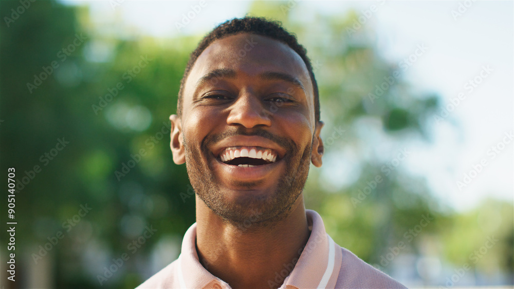 Young Man Smiling Brightly in a Sunny Park During Afternoon Gathering Young Man Smiling Brightly in a Sunny Park During Afternoon Gathering
