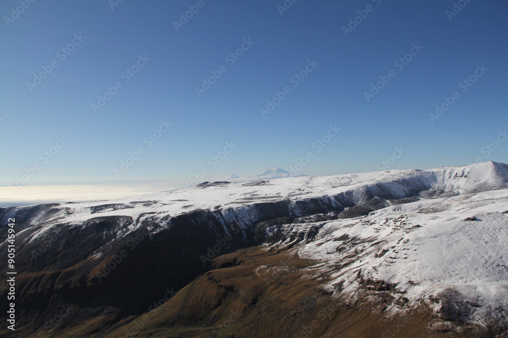 Breathtaking winter scenery with majestic snow-capped mountains glistening under the sun against a backdrop of a clear blue sky. Ideal for capturing the tranquil beauty of a winter wonderland. Breathtaking winter scenery with majestic snow-capped mountains glistening under the sun against a backdrop of a clear blue sky. Ideal for capturing the tranquil beauty of a winter wonderland.