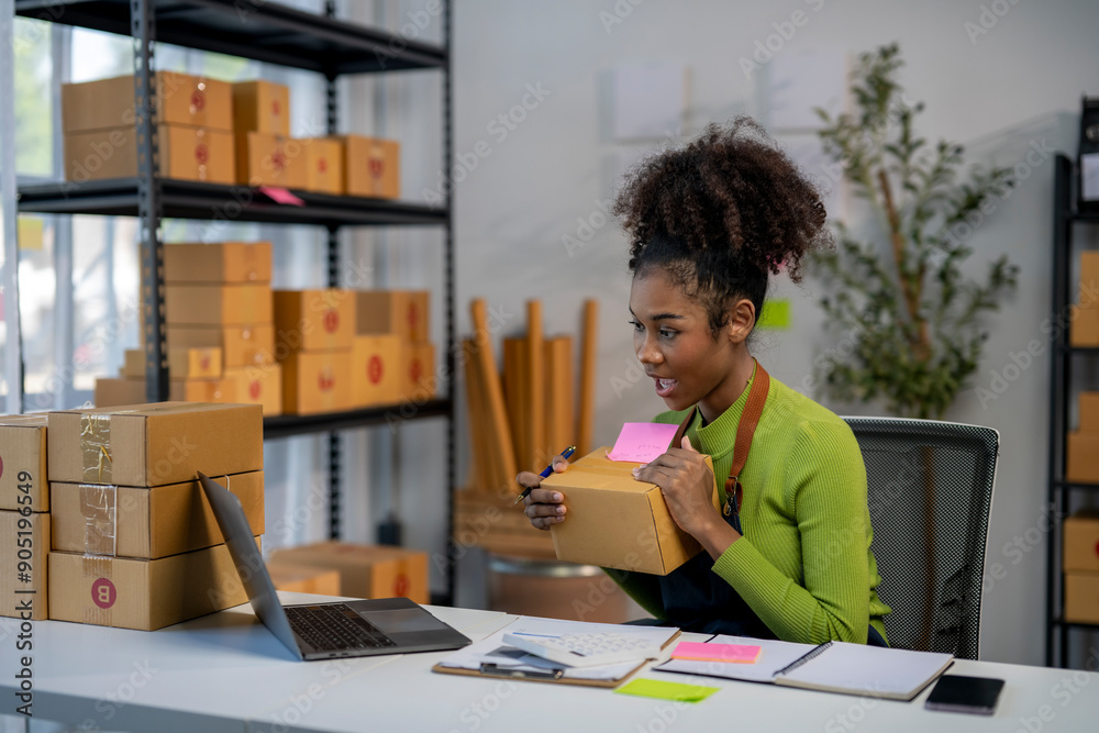 A woman is sitting at a desk with a laptop and a box in front of her A woman is sitting at a desk with a laptop and a box in front of her