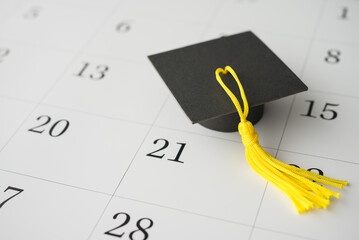 Graduation cap or mortarboard on white blank calendar background. University graduation ceremonies on commencement day schedule. Education, learning successful for future concept.