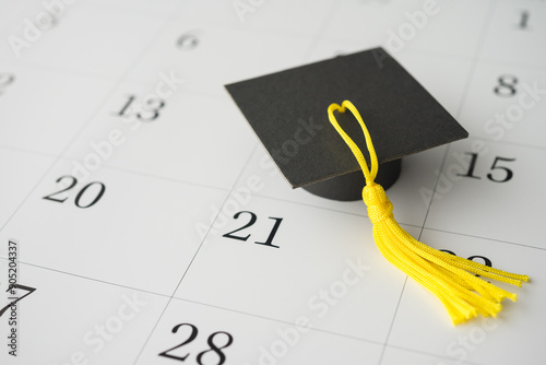 Graduation cap or mortarboard on white blank calendar background. University graduation ceremonies on commencement day schedule. Education, learning successful for future concept.