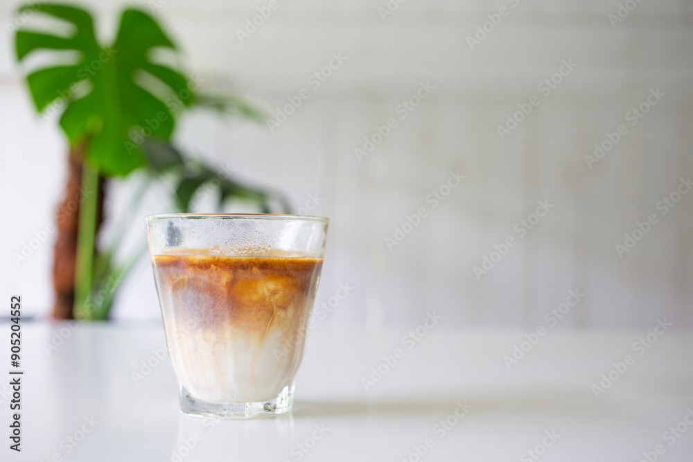 ice cup of coffee sits on a home table beside a glass of milk and a slightly dirty menu,copy space for your text. ice cup of coffee sits on a home table beside a glass of milk and a slightly dirty menu,copy space for your text.