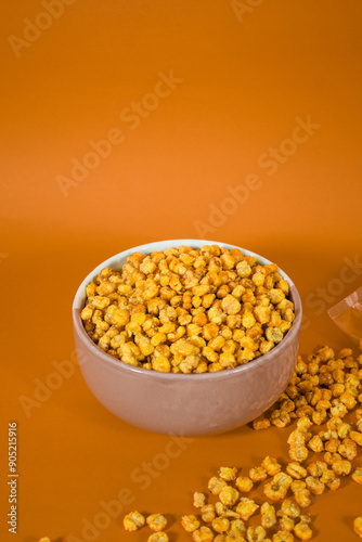 Corcflakes or Marning or marneng is traditional snack from indonesia. Made from corn kernels that fried. Fried corn in bowl with isolated background photo