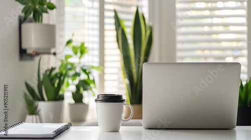 Modern home office with laptop, coffee mug, notebook, and indoor plants on white desk. Clean workspace backdrop