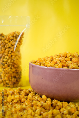 Corcflakes or Marning or marneng is traditional snack from indonesia. Made from corn kernels that fried. Fried corn in bowl with isolated background photo