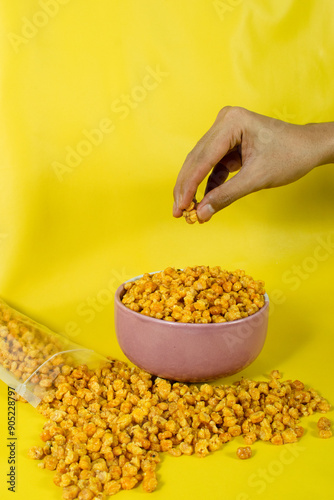 Corcflakes or Marning or marneng is traditional snack from indonesia. Made from corn kernels that fried. Fried corn in bowl with isolated background photo