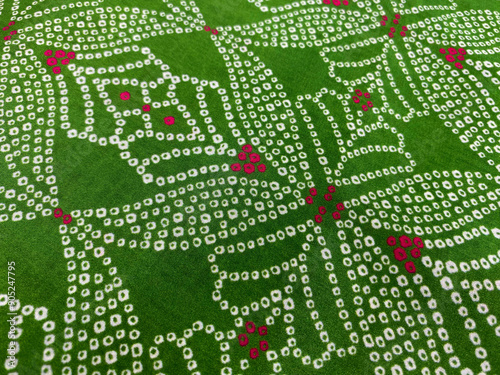 Close up of white and red geometric design bandini digitally printed on green gaji silk photo