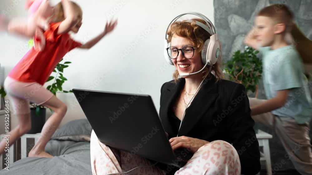 Remote work at home: A girl in a jacket and pajamas, a call worker contacts a client via video conference. Children run around, make loud noises and get in the way.