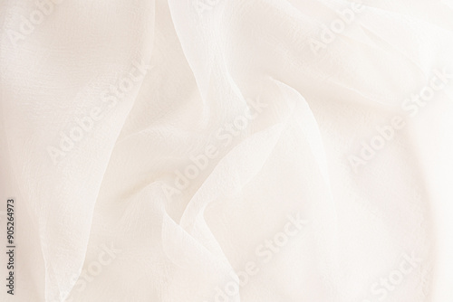 delicate soft folds of chiffon, silk, transparent fabric in champagne, ivory, beige as a wedding background with a copy space.