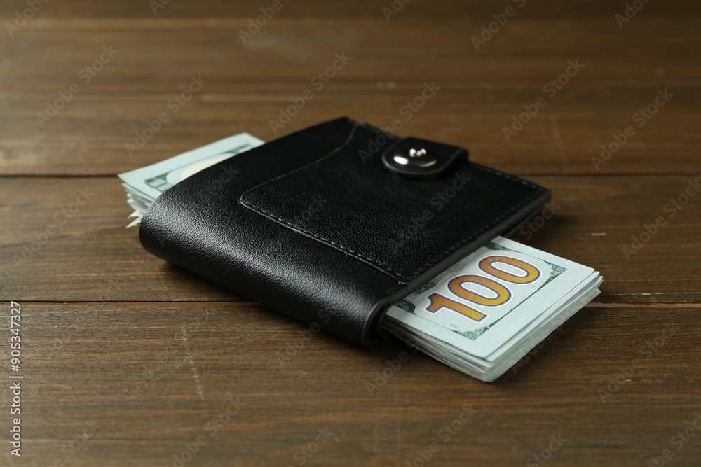 Leather wallet with dollar banknotes on wooden table Leather wallet with dollar banknotes on wooden table