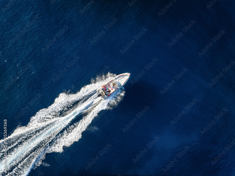 Aerial overhead view of a RIB Boat crossing the blue ocean with speed