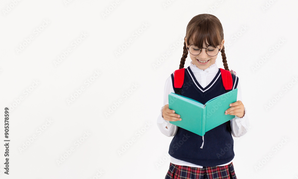 The girl really likes to read an interesting book. Girl in school uniform reading blue book The girl really likes to read an interesting book. Girl in school uniform reading blue book