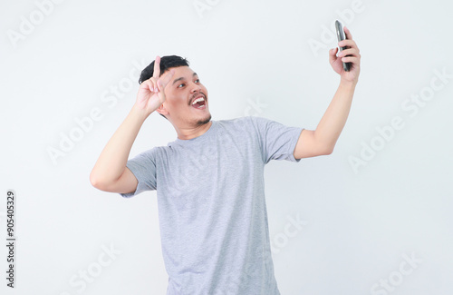 Adult Asian man taking a selfie photo with happy expression photo