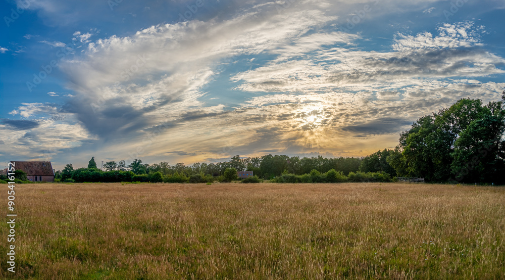 Sunset above a meadow in an agricultural region near Winterswijk on a nice summer evening in July. Sunset above a meadow in an agricultural region near Winterswijk on a nice summer evening in July.