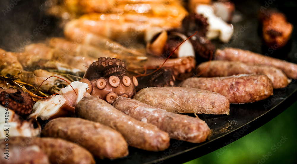 Cooking shrimp, octopus and sausage on a large grill Cooking shrimp, octopus and sausage on a large grill