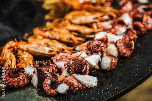 Obraz na płótnie Cooking shrimp, octopus and sausage on a large grill w salonie