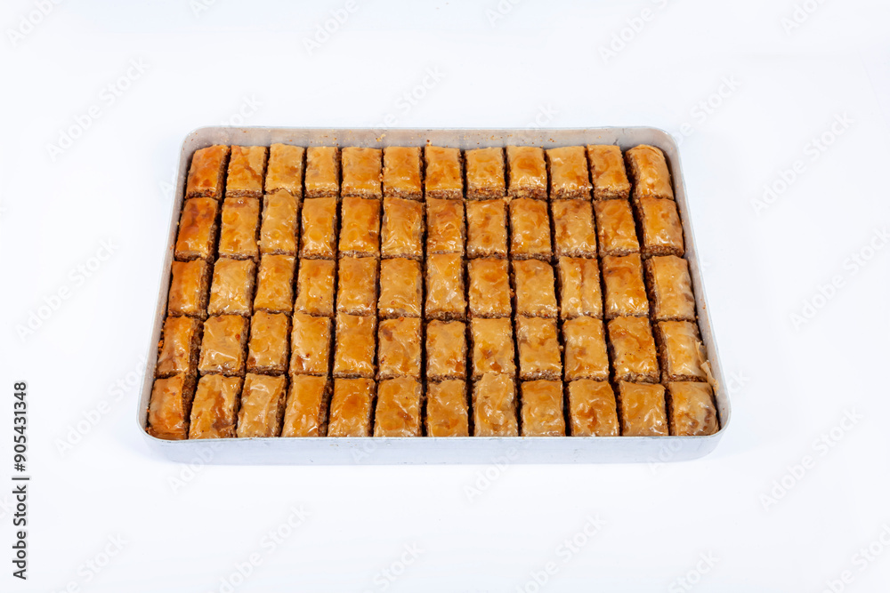 Top view of baked pistachio or walnut baklava on a tray isolated on white background. Top view of baked pistachio or walnut baklava on a tray isolated on white background.