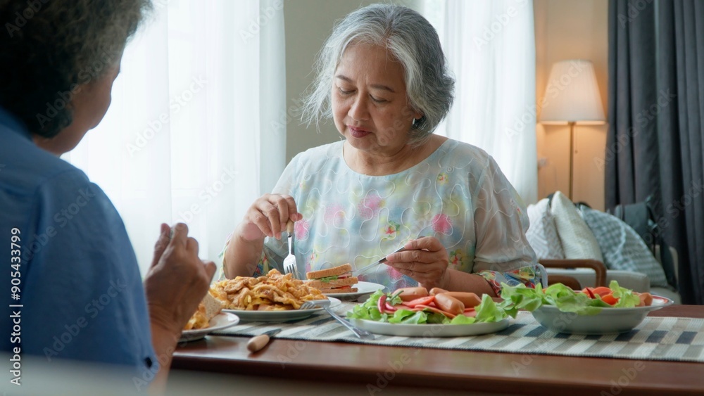 Group of Joyful senior women with gray hair having breakfast together at home. Elderly retired woman friends enjoying a plate of food, exuding warmth and contentment. Enjoy the retirement life concept Group of Joyful senior women with gray hair having breakfast together at home. Elderly retired woman friends enjoying a plate of food, exuding warmth and contentment. Enjoy the retirement life concept