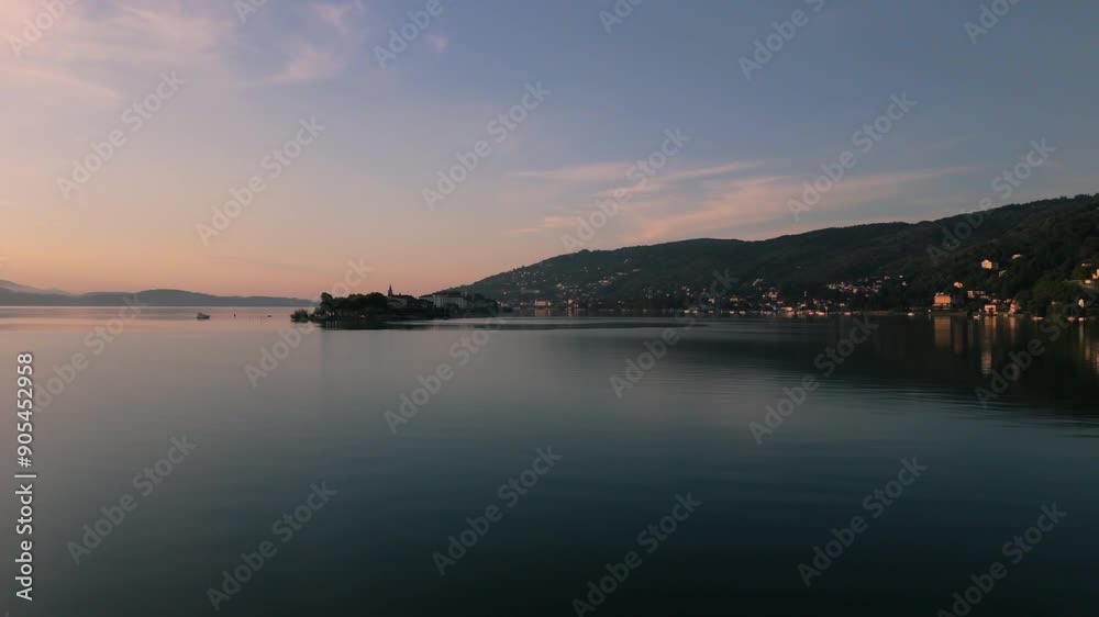 Drone shot of Lago Maggiore reveals Stresa and Isola Bella islands illuminated by the morning sun. Drone shot of Lago Maggiore reveals Stresa and Isola Bella islands illuminated by the morning sun.