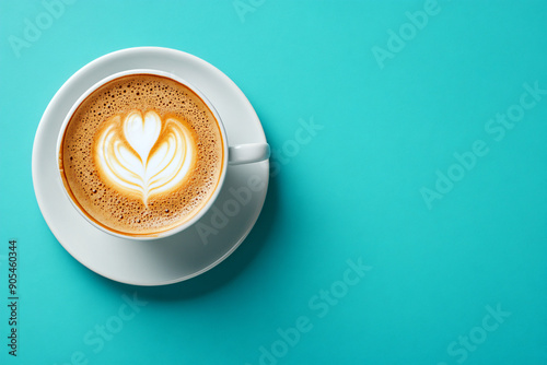 White cap of cappuccino with milk foam on bright blue turquoise background. Flat lay with black hot coffee mug. Coffee love minimal trendy concept. top view backdorp with copy space. photo