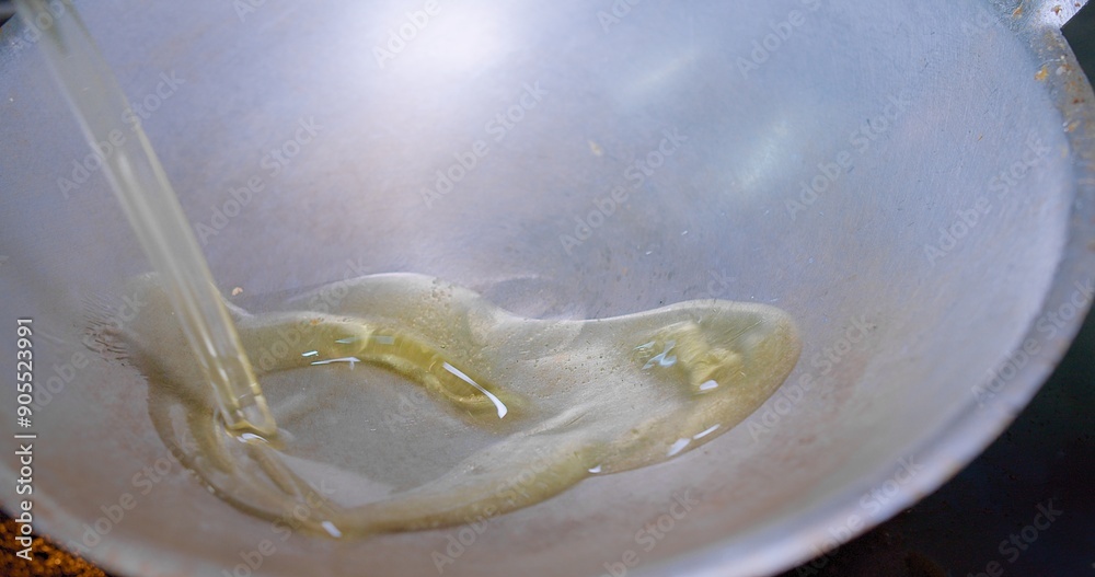 Close-up view of oil being poured into a hot wok with smoking ready for cooking, Close-Up View of Oil Flowing into a Pan in a Kitchen, Perfect for culinary, kitchen and cooking-related themes. Close-up view of oil being poured into a hot wok with smoking ready for cooking, Close-Up View of Oil Flowing into a Pan in a Kitchen, Perfect for culinary, kitchen and cooking-related themes.
