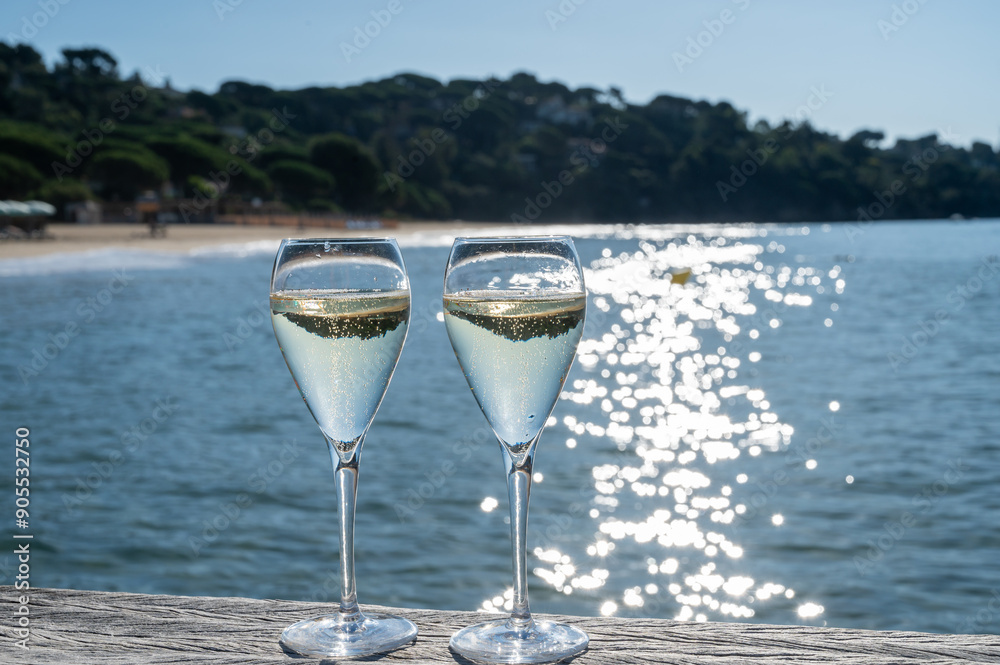 Summer time in Provence, two glasses of cold champagne cremant sparkling wine on famous Pampelonne sandy beach near Saint-Tropez in sunny day, Var department, France, beach club party Summer time in Provence, two glasses of cold champagne cremant sparkling wine on famous Pampelonne sandy beach near Saint-Tropez in sunny day, Var department, France, beach club party