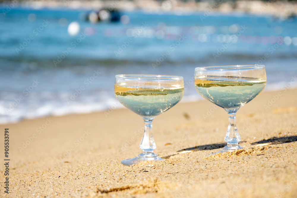 Summer time on French Riviera, two coupe glasses of champagne cremant sparkling wine on Pampelonne sandy beach near Saint-Tropez in sunny day, Var, vacation in France Summer time on French Riviera, two coupe glasses of champagne cremant sparkling wine on Pampelonne sandy beach near Saint-Tropez in sunny day, Var, vacation in France