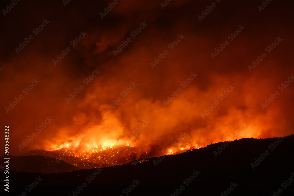 Reflections of a massive wildfire blaze in the night over the hills Reflections of a massive wildfire blaze in the night over the hills