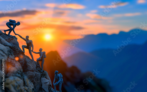 Silhouetted climbers helping each other ascend a rocky mountain at sunset with a vibrant sky in the background